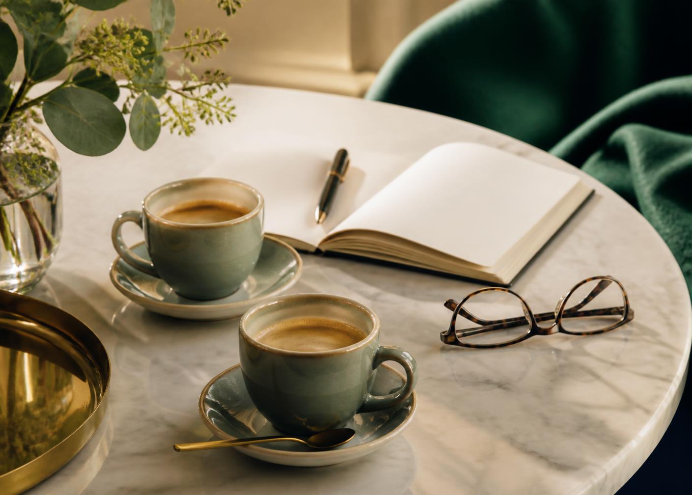 Deux tasses de café sur une table en marbre, symbole d'un échange de confiance avec MC Gestion 34